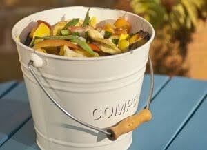 Backyard compost bin filled with organic waste like vegetable peels and leaves